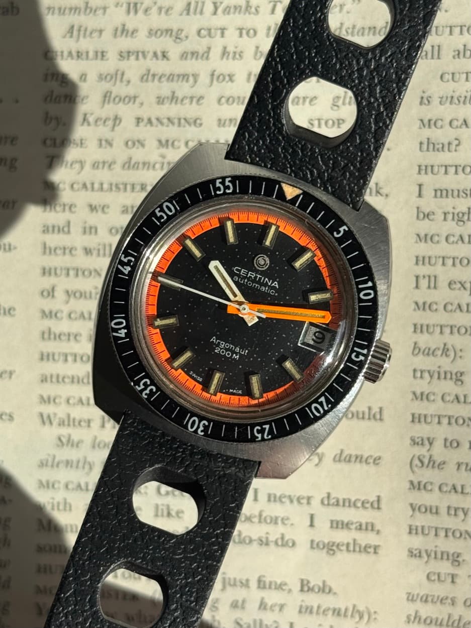 Vintage skin diver with orange accents on a black tropic strap