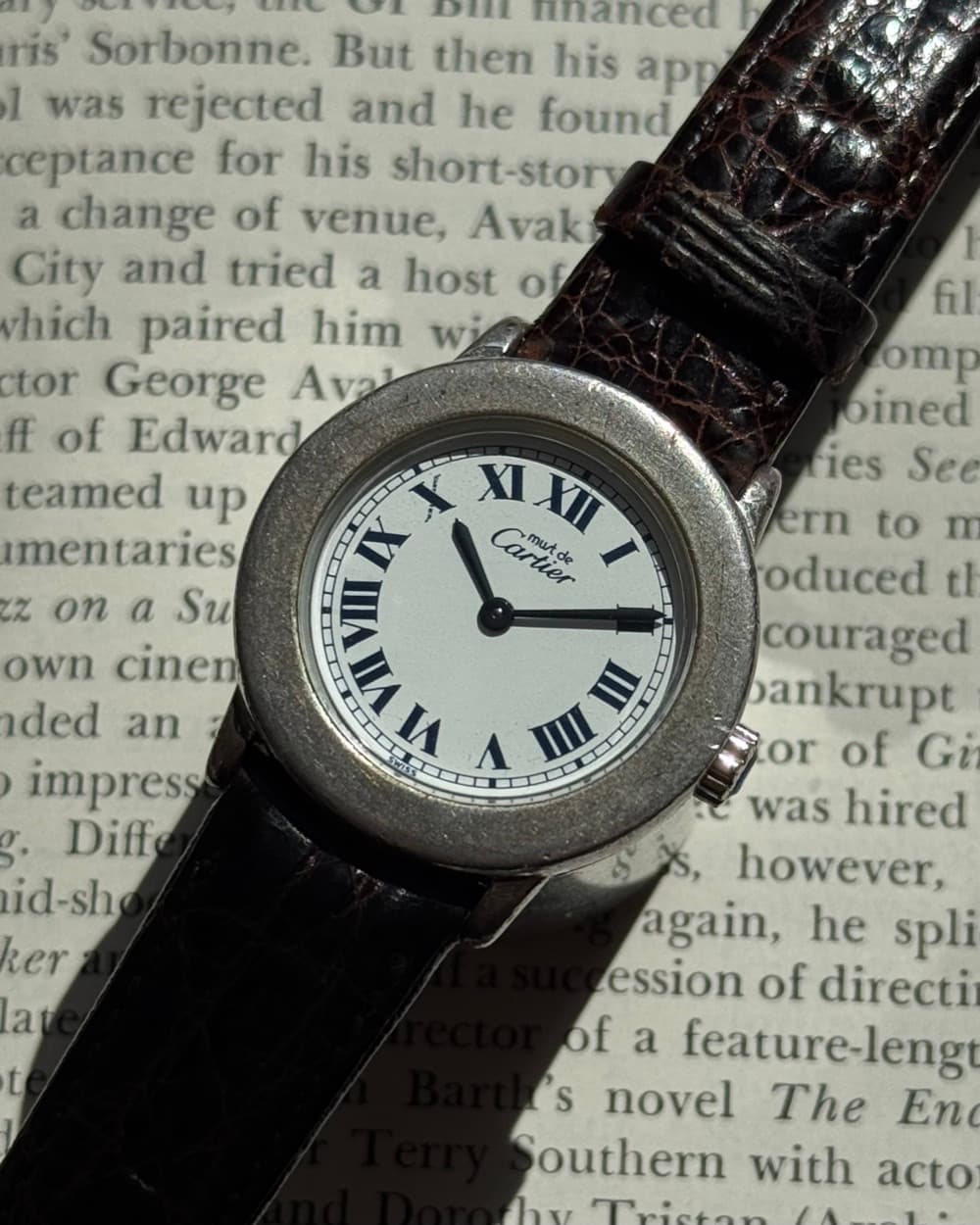 Cartier with white Roman-numeral dial on a burgundy leather strap